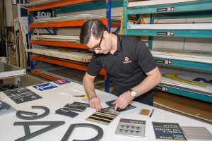 Miller McConnell staff member working on braille signage